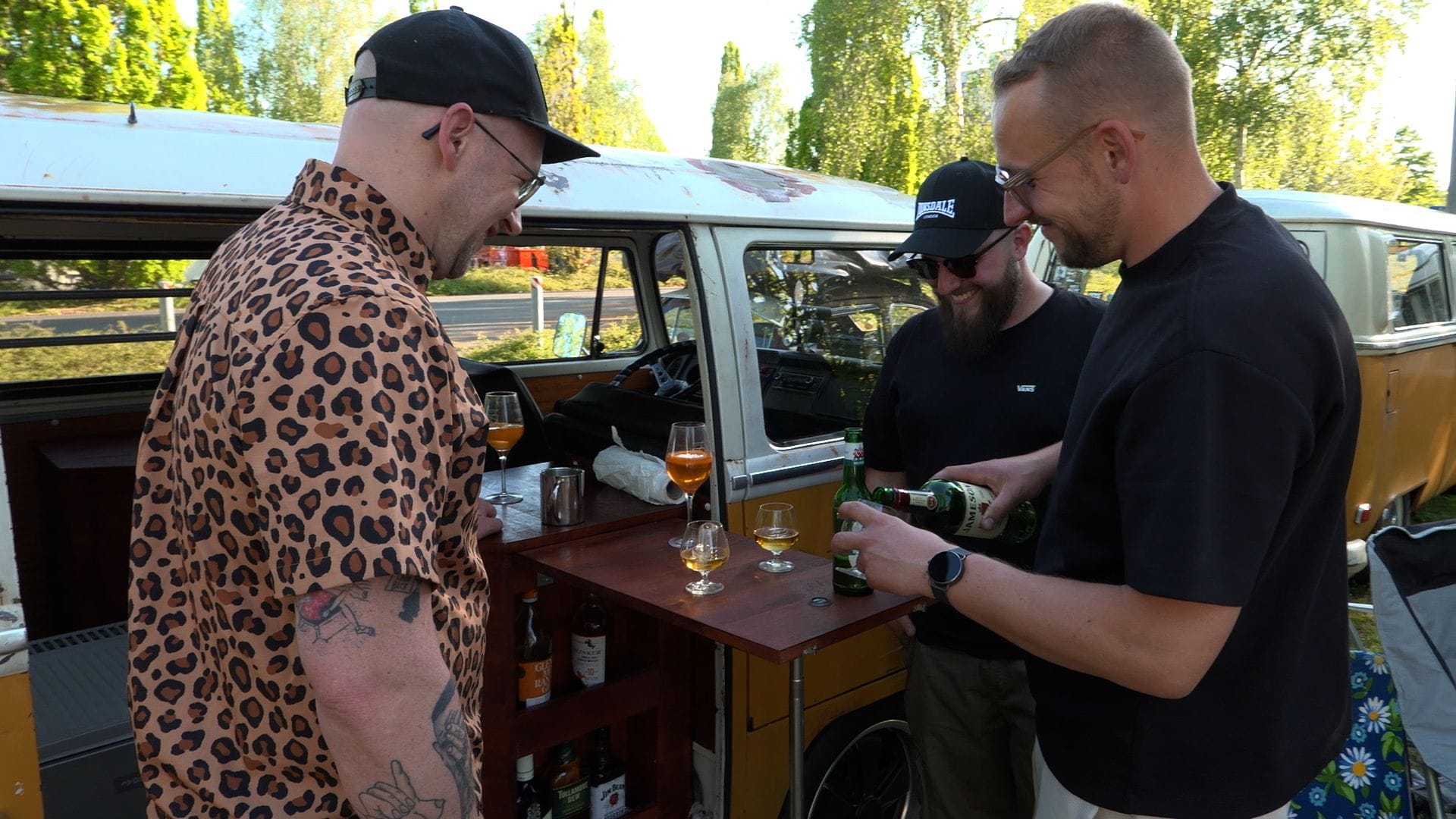 Mahagonibar statt Mittelkonsole: Nick Ramm (rechts) schenkt in seinem restaurierten Bulli Whisky aus. Zusammen mit Freunden genießt er die Sonne. Mahagonibar statt Mittelkonsole: Nick Ramm (rechts) schenkt in seinem restaurierten Bulli Whisky aus. Zusammen mit Freunden genießt er die Sonne.