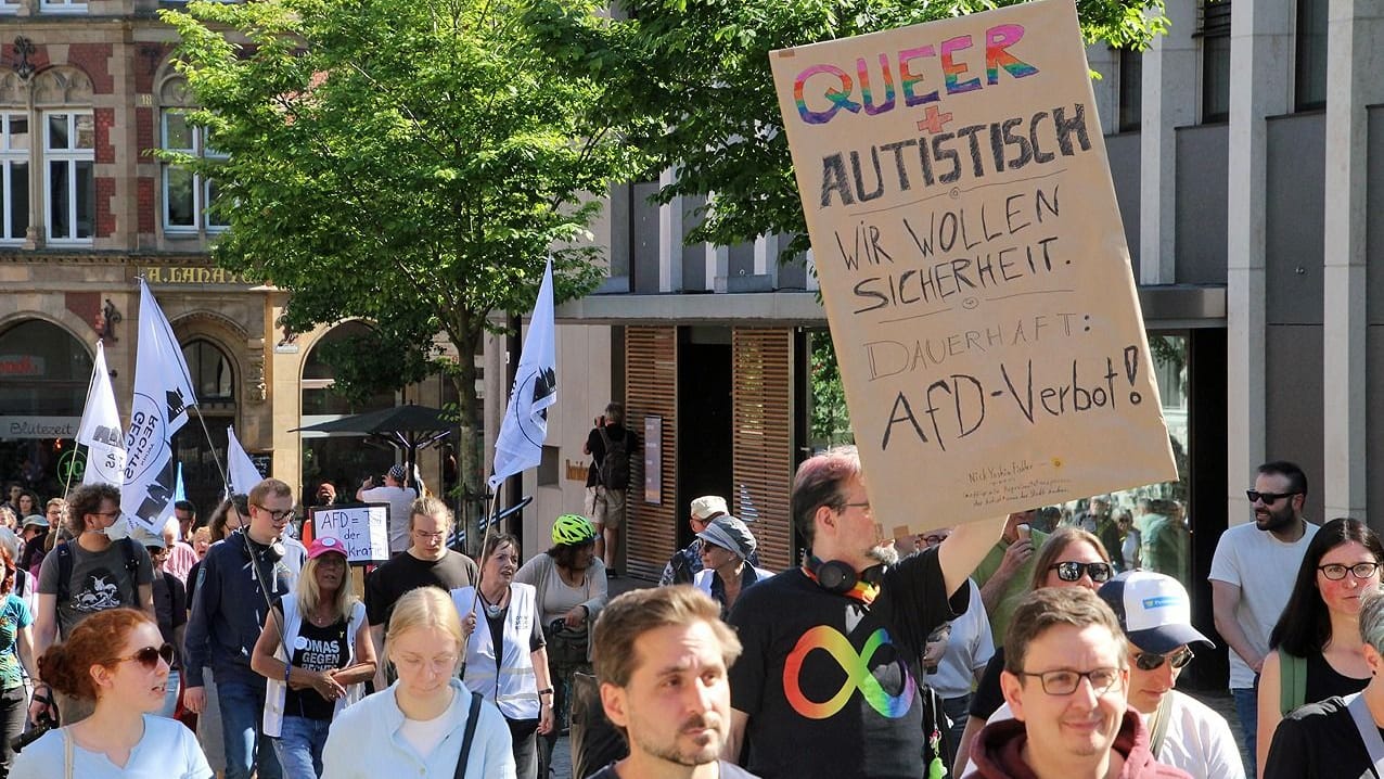 Ein Demonstrant hält ein Anti-AfD-Plakat in der Hand.