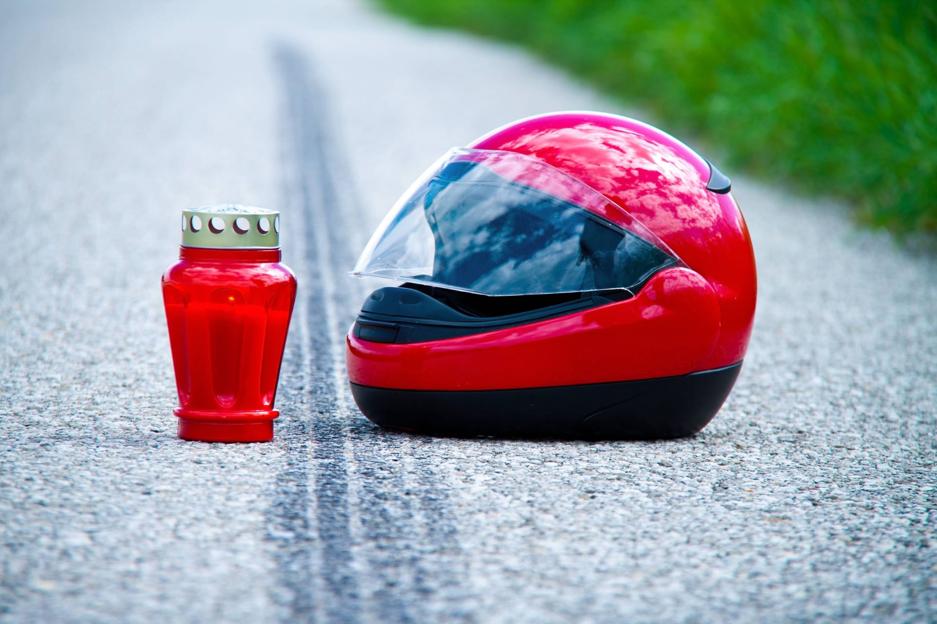 Roter Motorradhelm und Grablicht auf Asphalt mit Bremsspur (Archivbild): Bei dem tödlichen Unfall am Dienstagabend war auch ein Rettungshubschrauber im Einsatz.