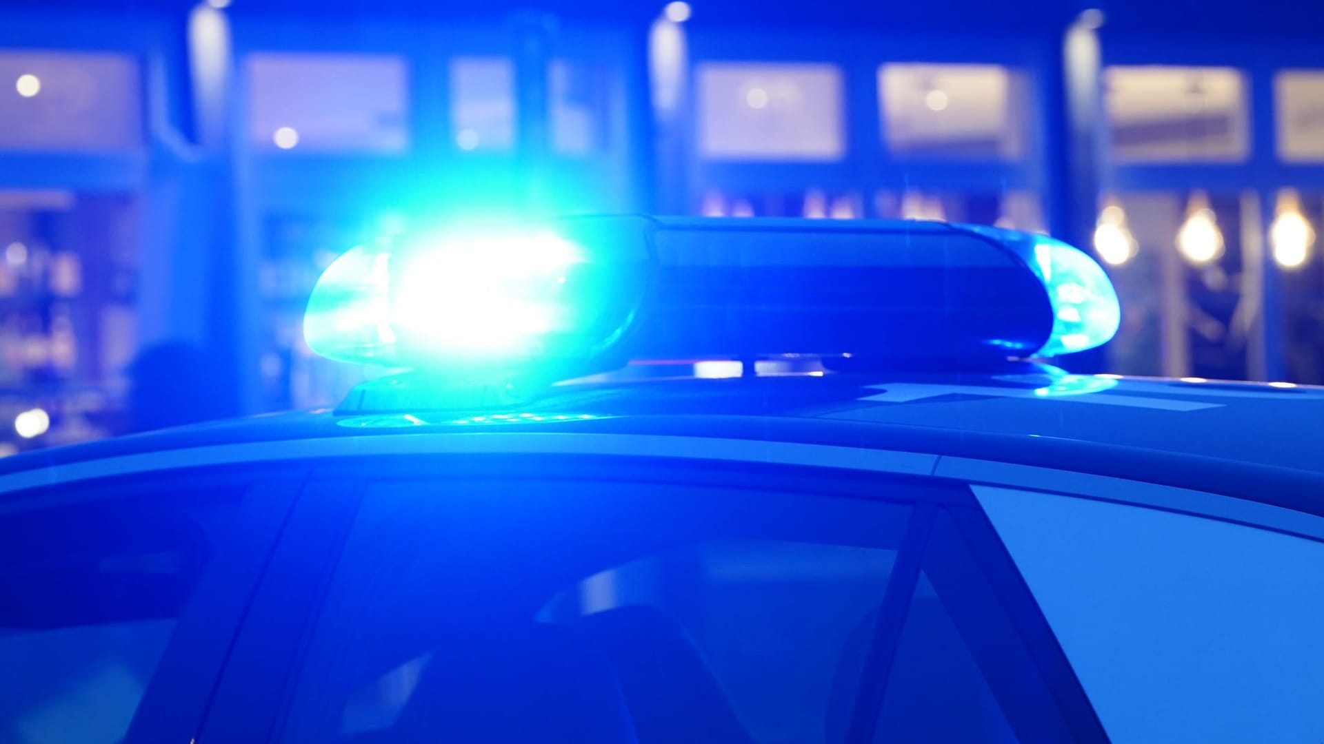 Ein Streifenwagen der Polizei mit eingeschaltetem Blaulicht Ein Streifenwagen der Polizei mit eingeschaltetem Blaulicht