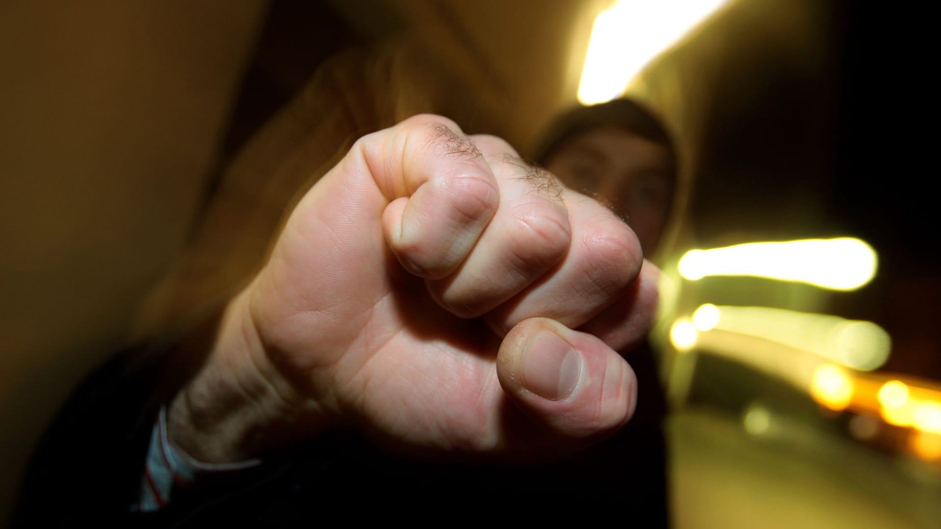 Junger Mann hebt seine geballte Faust Junger Mann hebt seine geballte Faust