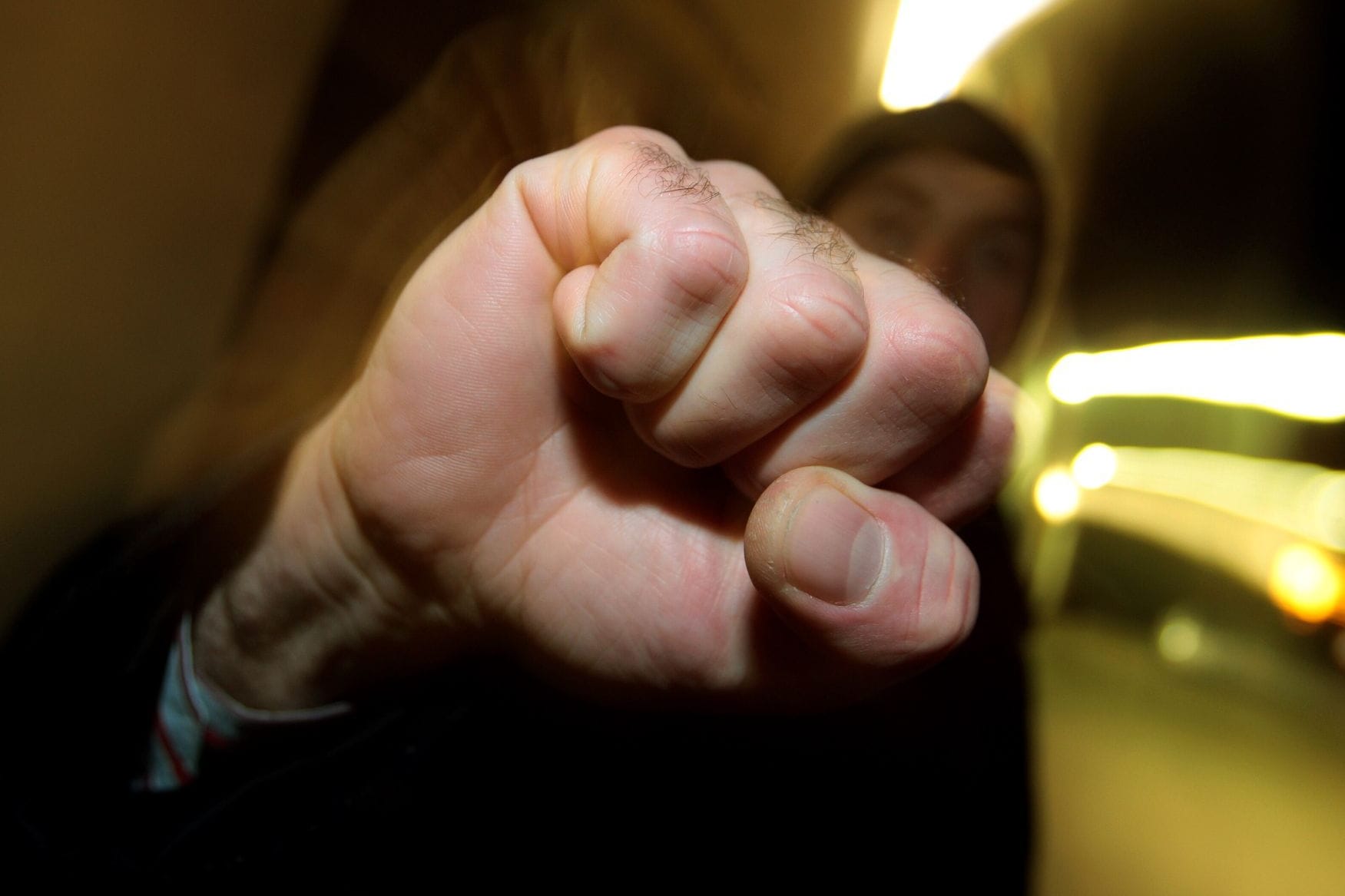 Junger Mann hebt seine geballte Faust