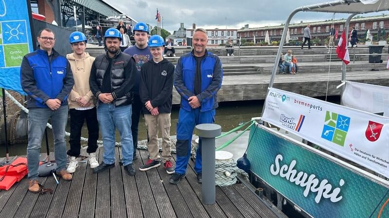 "Schuppi" und die Menschen hinter der Mini-Fähre (Archivfoto): Zur "Sail 2025" soll das autonom fahrende Boot einsatzbereit sein. "Schuppi" und die Menschen hinter der Mini-Fähre (Archivfoto): Zur "Sail 2025" soll das autonom fahrende Boot einsatzbereit sein.