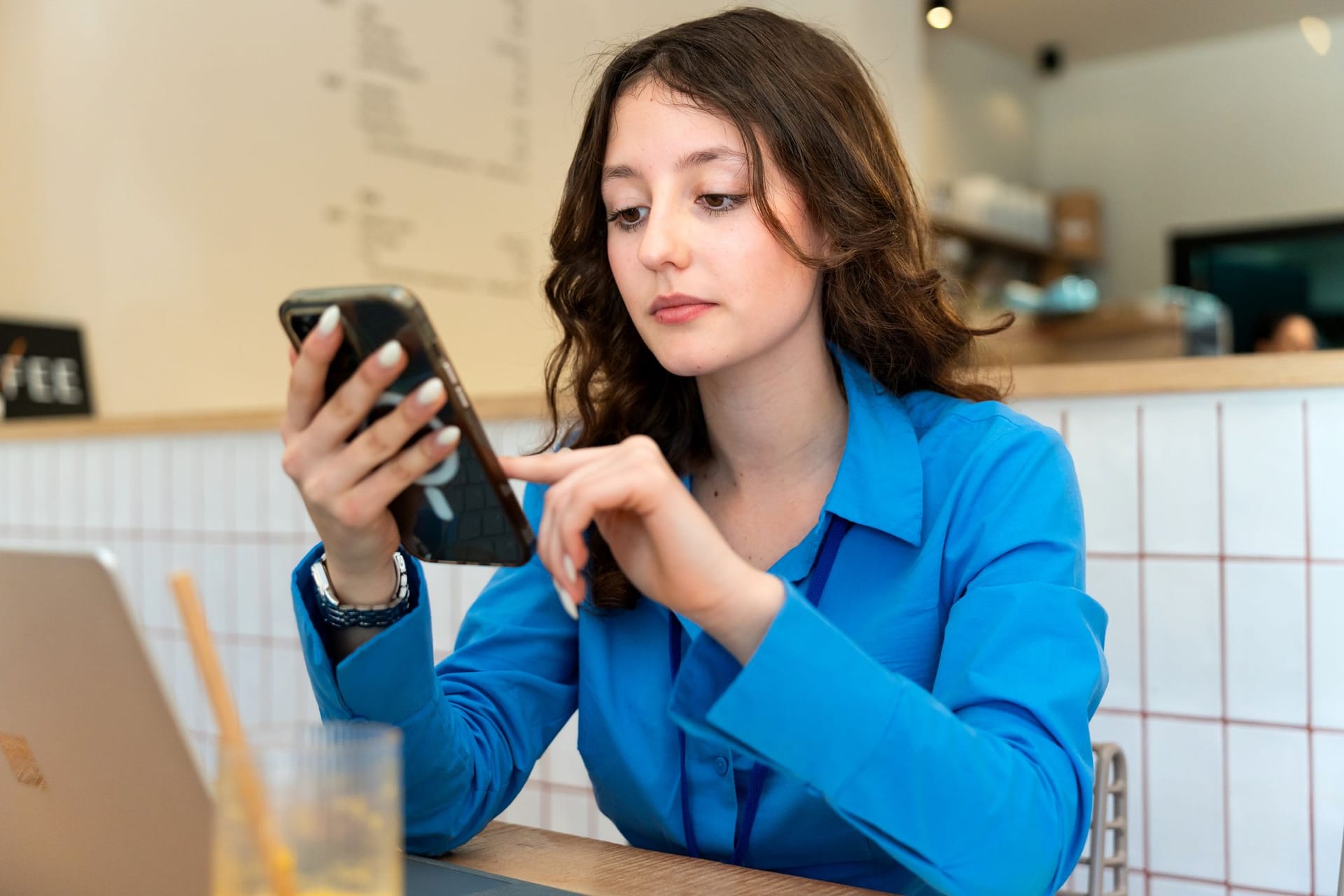 Eine Frau am Smartphone: An der Börse gibt es auch vergleichsweise sichere Produkte.