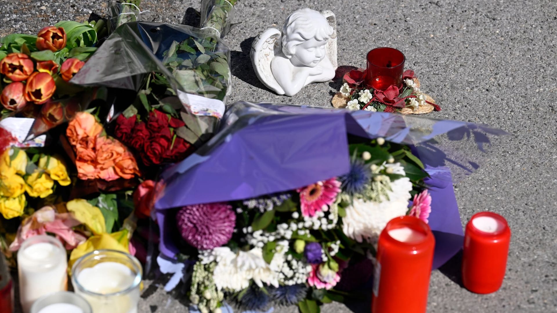 Menden: Trauernde haben an der Stelle, wo ein 17-jähriger einen 14-jährigen Jungen erstochen haben soll, Blumen niedergelegt und Kerzen aufgestellt.