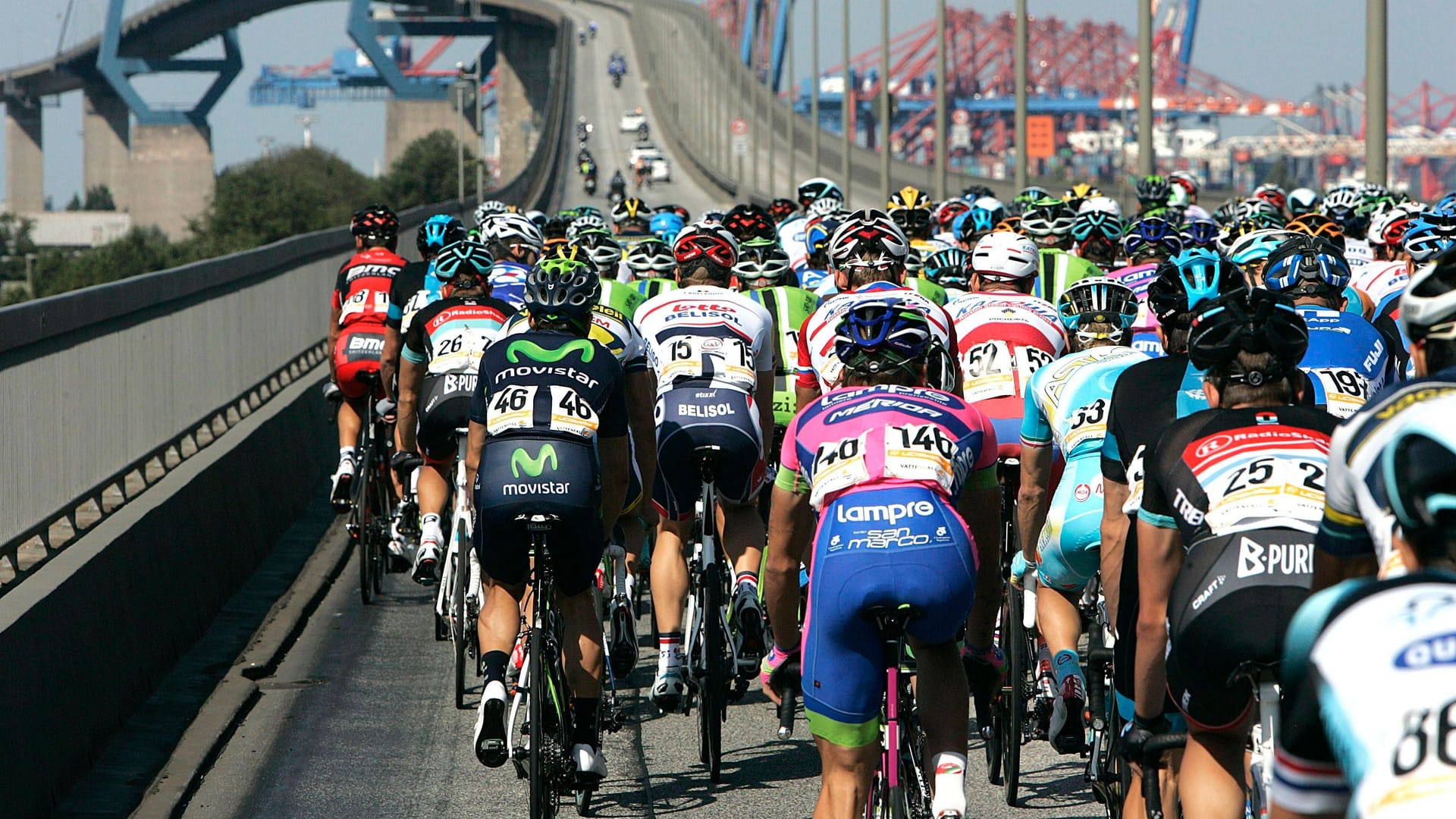 Radprofis fahren über die Köhlbrandbrücke (Archivbild): Nach vielen Jahren gehört das Wahrzeichen im Hamburger Hafen 2025 wieder zur Cyclassics-Strecke. Radprofis fahren über die Köhlbrandbrücke (Archivbild): Nach vielen Jahren gehört das Wahrzeichen im Hamburger Hafen 2025 wieder zur Cyclassics-Strecke.