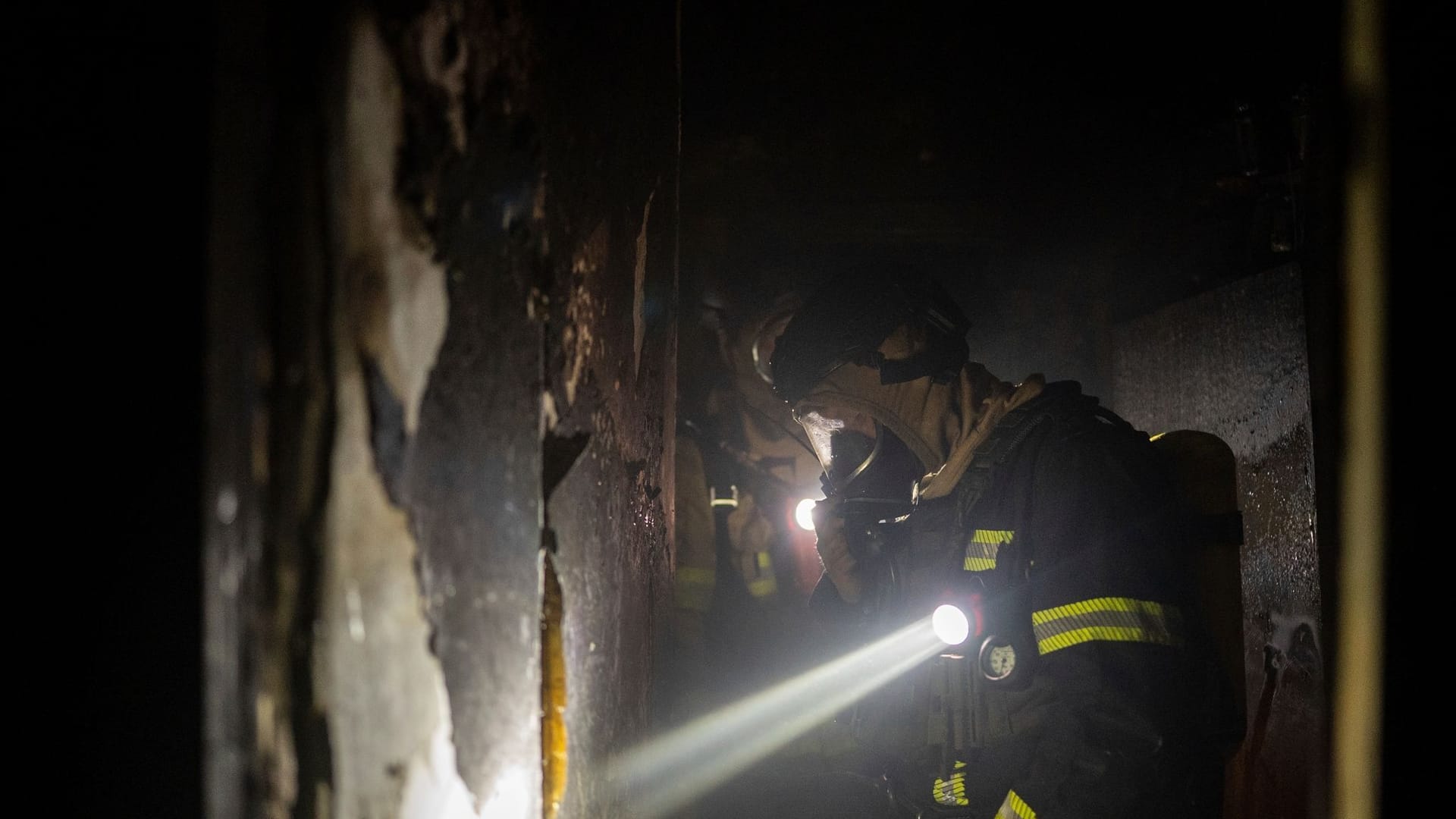 Feuerwehrleute arbeiten in einem Wohnhaus, das nach einem russischen Angriff beschädigt wurde.