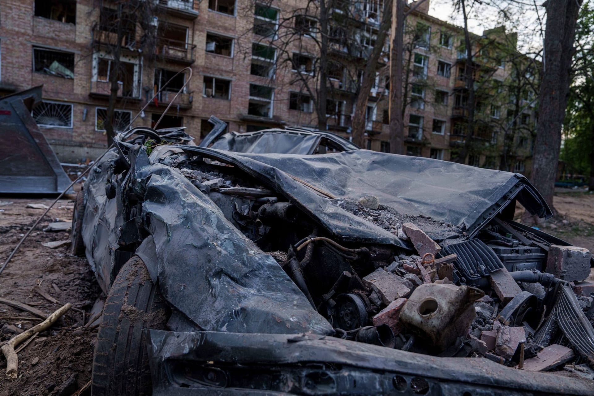 Ein zerstörtes Auto ist vor einem Haus zu sehen, das bei einem russischen Angriff auf ein Wohnviertel in Kiew beschädigt wurde. (Archivbild)