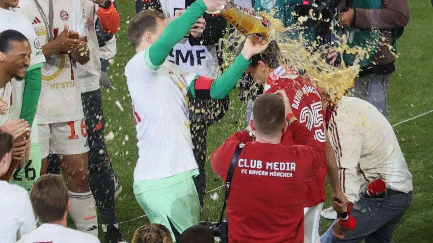 Bierdusche: Bayern-Torwart Neuer erwischt Müller nach seiner Rede.