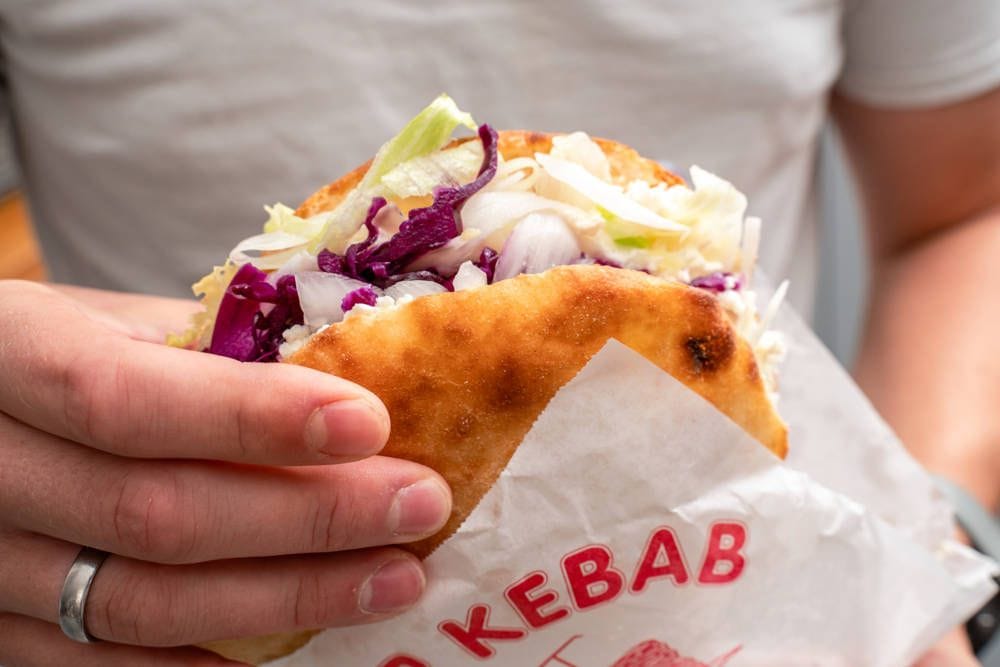 Mann hält einen Döner (Symbolfoto): In der Dresdner Neustadt gibt es am Donnerstag ein besonderes Angebot.