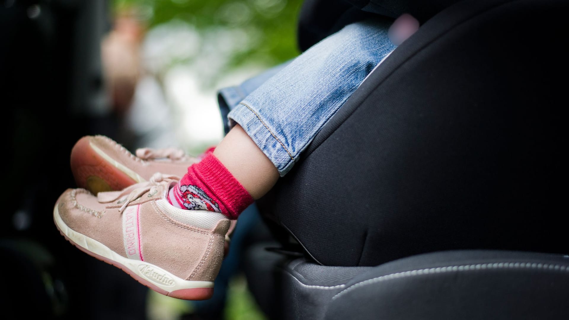 Mädchen sitzt in einem Kindersitz im Auto