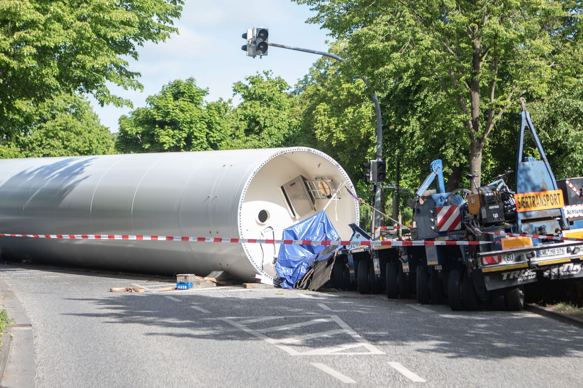 In der Nacht zum Freitag (16.05.2025) ist in Elmshorn (Landkreis Pinneberg) ein Schwertransporter am Rande der Innenstadt verunglückt. Der Lkw hatte ein tonnenschweres Bauteil einer Windkraftanlage geladen, das bei dem Unfall vom Auflieger stürzte und seitdem den Heidmühlenweg blockiert. Nach Angaben der Polizei kam das Fahrzeug gegen 2 Uhr aus bislang ungeklärter Ursache von der Fahrbahn ab. Zwei weitere Transporter, die zum selben Konvoi gehören, stehen derzeit hinter der Unfallstelle fest, ein Wenden oder Zurücksetzen ist aufgrund ihrer Größe nicht möglich.Die Bergung des Windrad-Teils gestaltet sich aufwendig und kann voraussichtlich erst in der kommenden Woche erfolgen. Spezielle Technik und Fahrzeuge sind dafür notwendig. Der betroffene Bereich bleibt bis dahin gesperrt, der Verkehr wird weiträumig umgeleitet. Foto: NEWS5 / Sebastian Peters Weitere Informationen... https://www.news5.de/news/news/read/36603