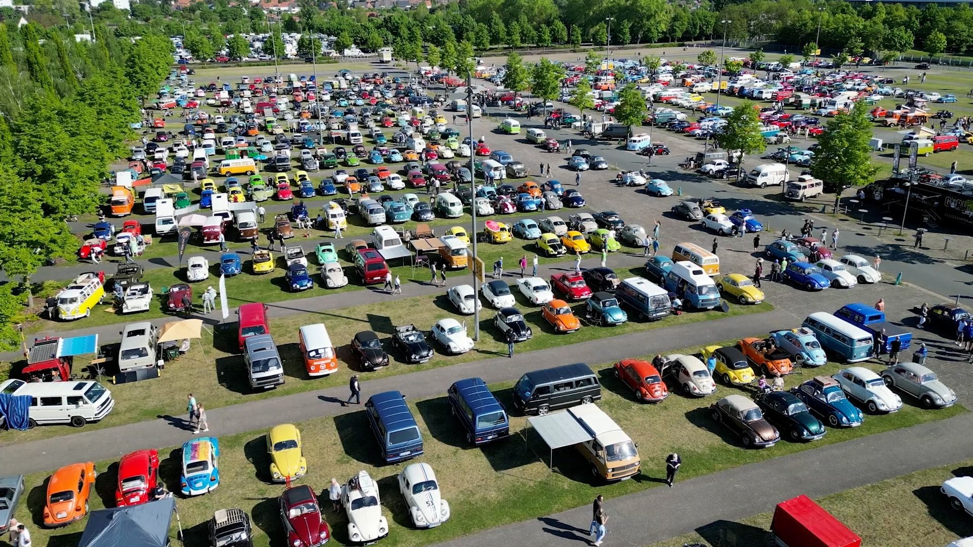 Supertotale aus der Luft: Das Maikäfertreffen füllt das Messegelände bis in die letzte Parklücke – Bullis, Käfer und bunte Szenegefährte wohin man schaut. Supertotale aus der Luft: Das Maikäfertreffen füllt das Messegelände bis in die letzte Parklücke – Bullis, Käfer und bunte Szenegefährte wohin man schaut.