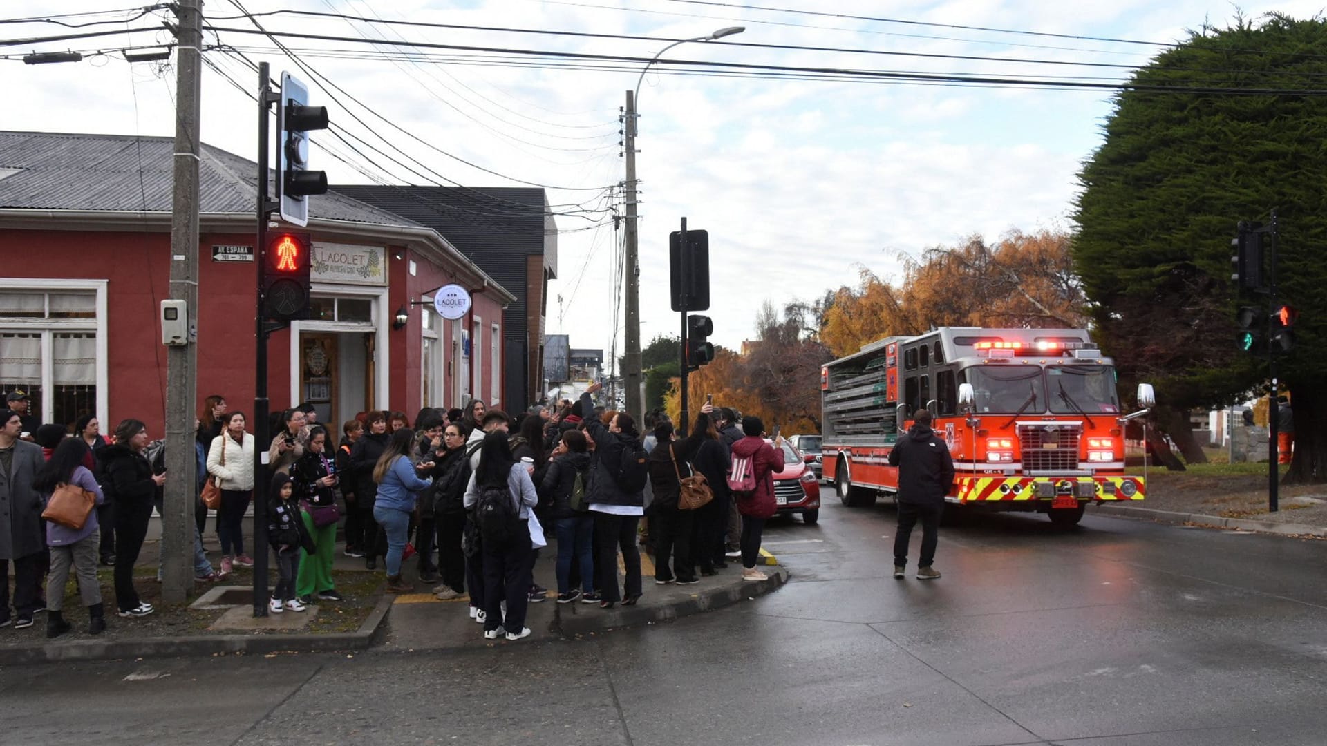 Menschen und Feuerwehrfahrzeug an Straßenecke: Tsunami-Warnung nach starkem Seebeben in Chile.