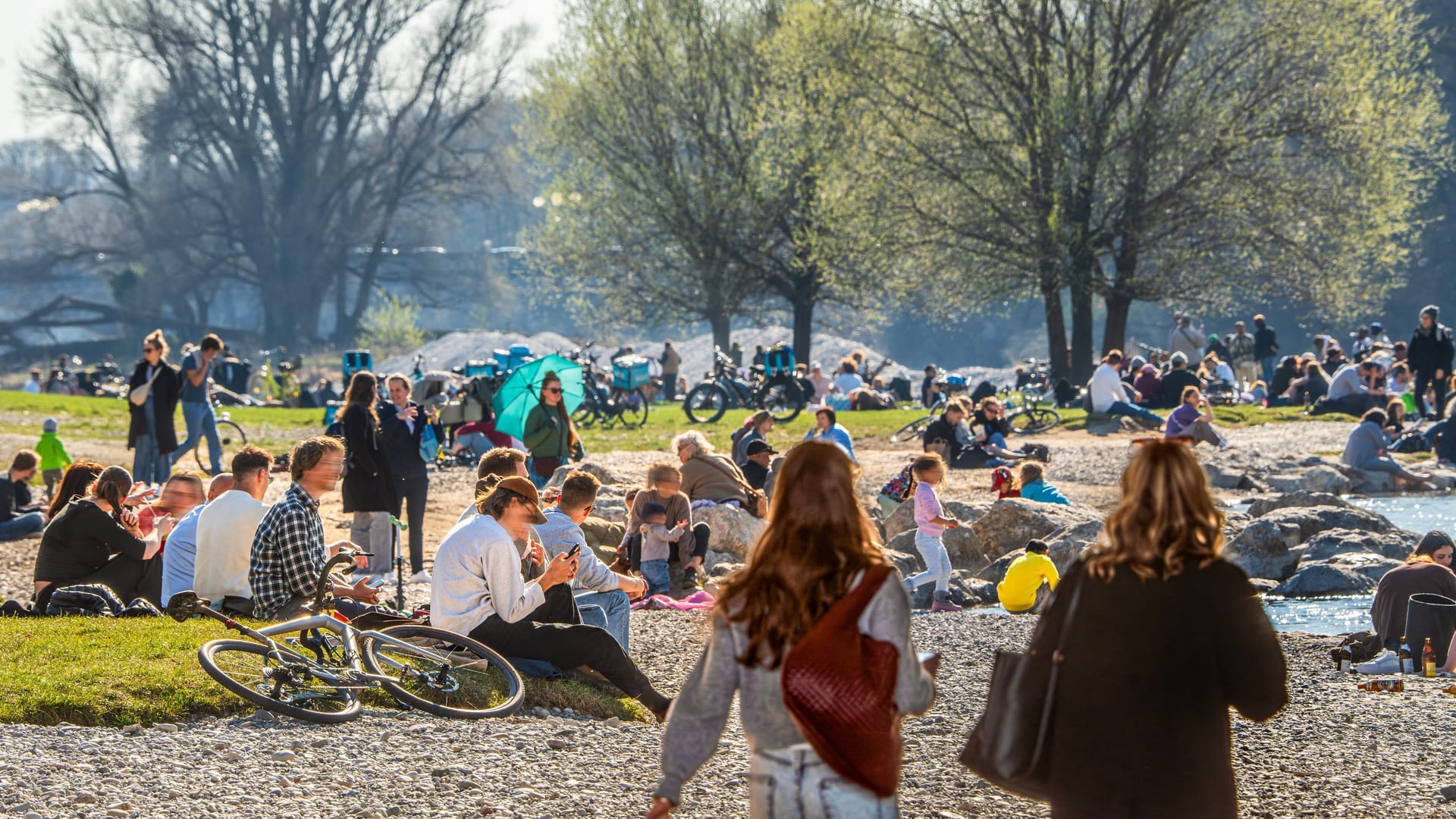 Menschen tanken Sonne in den Isarauen (Archivbild): Auch der Sonntag verspricht frühlingshaftes Wetter in München.