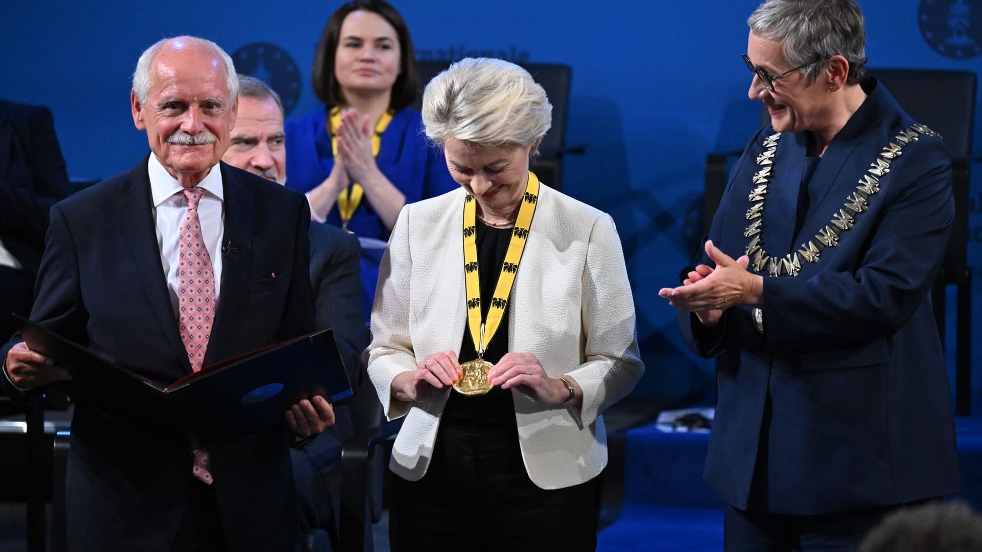 Aachen: Ursula von der Leyen (M), Präsidentin der Europäischen Kommission, betrachtet bei der Verleihung des Internationalen Karlspreises im Rathaus neben Jürgen Linden (l), Vorsitzender des Karlspreis-Direktoriums, und Sibylle Keupen (r), Oberbürgermeisterin von Aachen, die Medaille. Aachen: Ursula von der Leyen (M), Präsidentin der Europäischen Kommission, betrachtet bei der Verleihung des Internationalen Karlspreises im Rathaus neben Jürgen Linden (l), Vorsitzender des Karlspreis-Direktoriums, und Sibylle Keupen (r), Oberbürgermeisterin von Aachen, die Medaille.