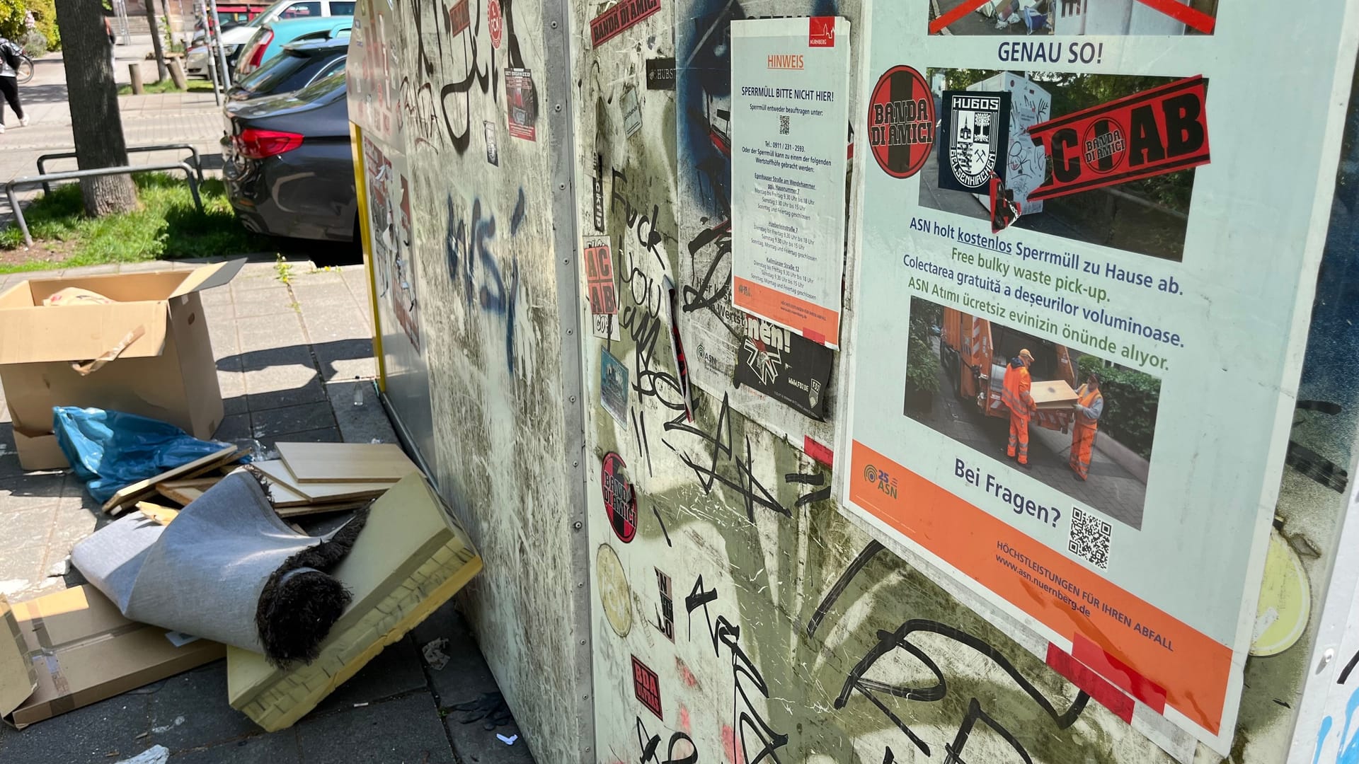 Aufkleber mit Zeichnungen auf den Glascontainern: Sie sollen erklären, wie Sperrmüll richtig entsorgt wird – doch der Müll steht einfach dahinter.