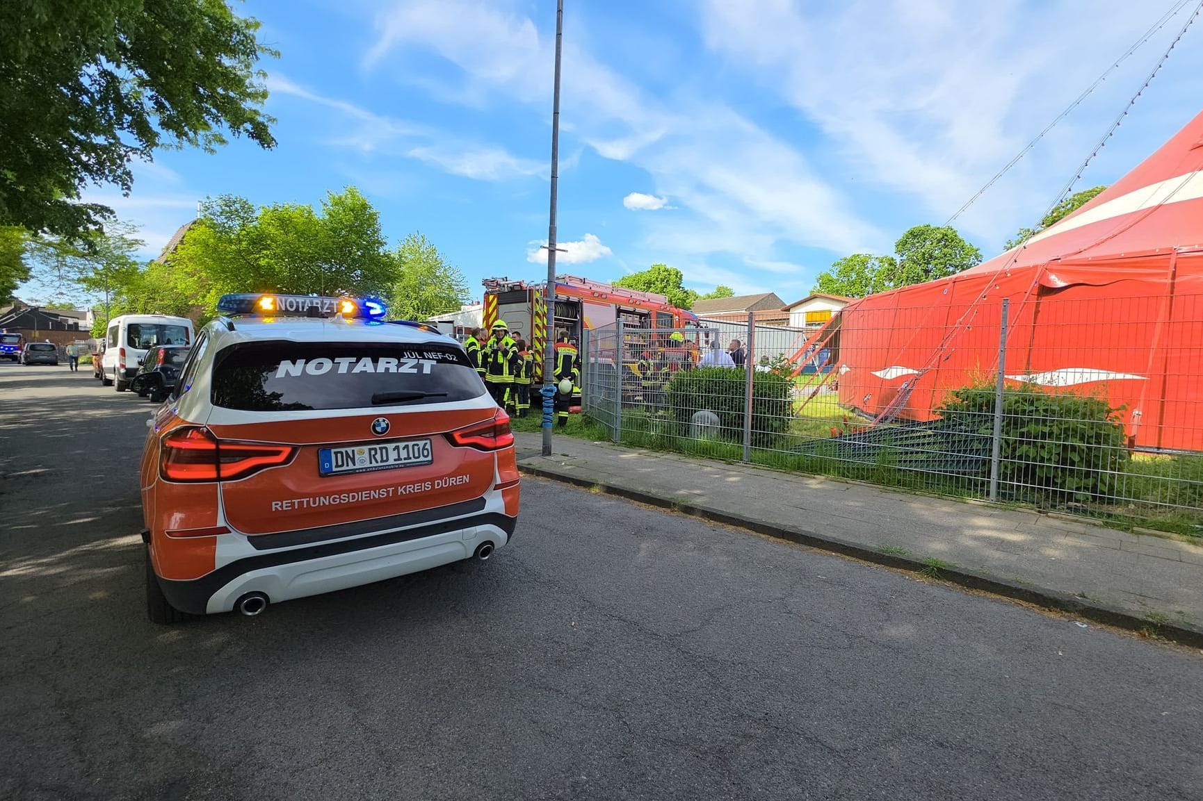 Aldenhoven: Ein Notarztfahrzeug steht vor einem Zirkuszelt. Beim Brand eines Zirkuszeltes im Kreis Düren sind 17 Kinder und drei Erwachsene verletzt worden.