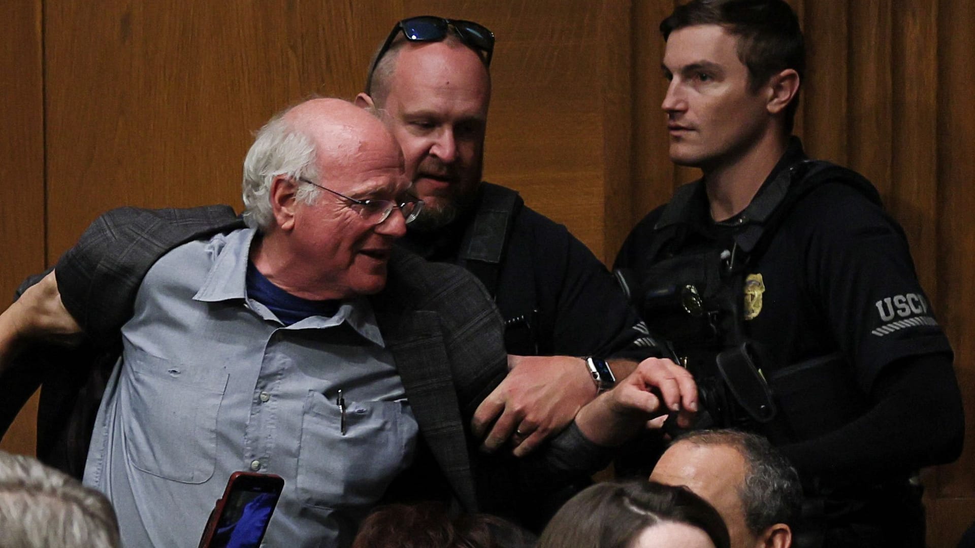 Ben Cohen, Mitbegründer der Eiscreme-Firma Ben & Jerry's, wird von Sicherheitsbeamten abgeführt.