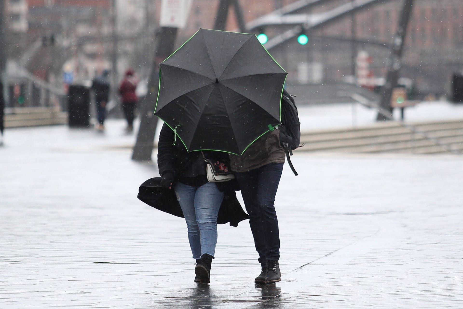 Mann und Frau laufen mit Regenschirm durch Sturm (Archivbild): Der Donnerstag und der Freitag werden extrem ungemütlich in Hamburg-