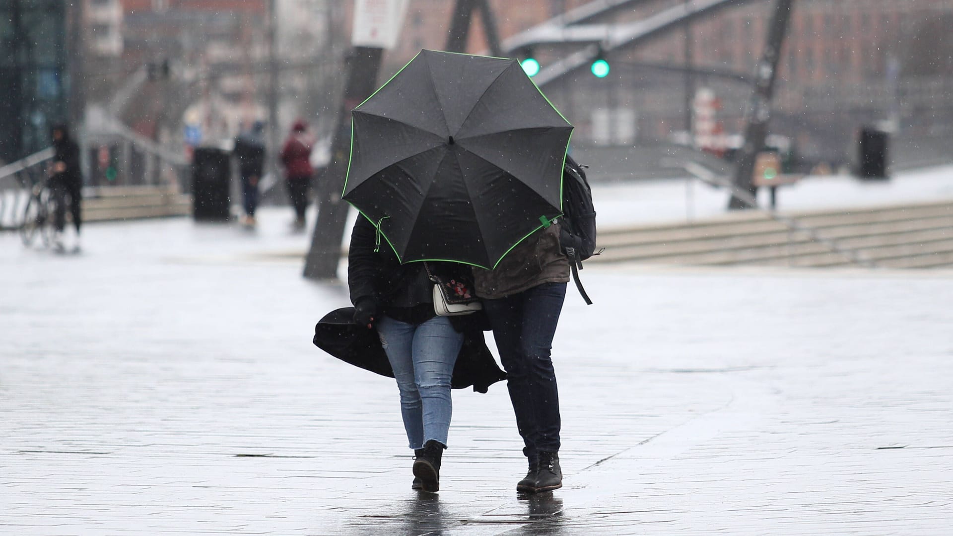 Mann und Frau laufen mit Regenschirm durch Sturm (Archivbild): Der Donnerstag und der Freitag werden extrem ungemütlich in Hamburg-