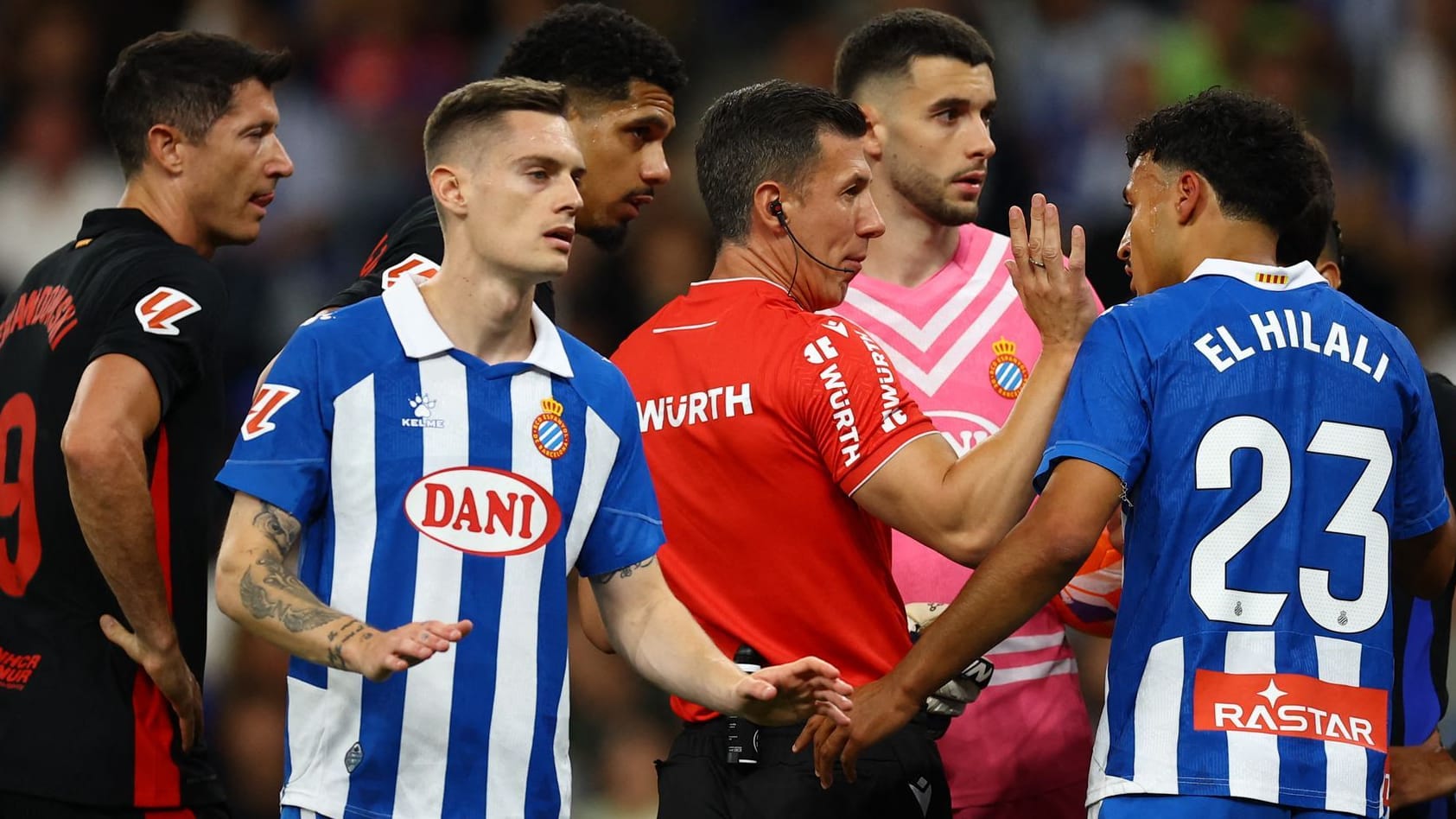 Besorgte Blicke: Spieler von Espanyol und Barça umringen Schiedsrichter Soto. Besorgte Blicke: Spieler von Espanyol und Barça umringen Schiedsrichter Soto.