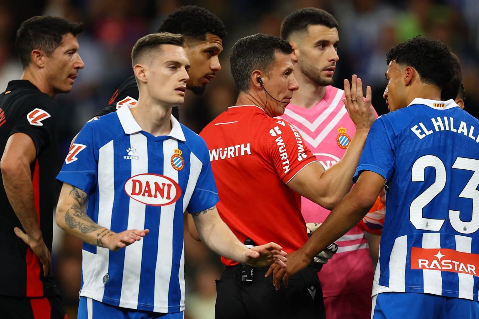 Besorgte Blicke: Spieler von Espanyol und Barça umringen Schiedsrichter Soto.