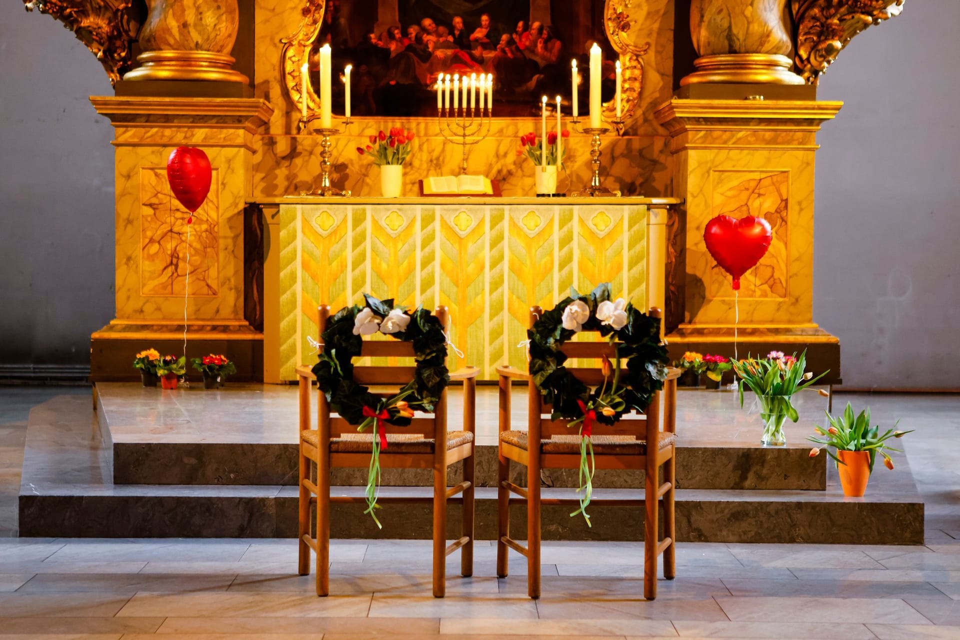 Geschmückte Stühle stehen vor dem Altar einer Kirche Geschmückte Stühle stehen vor dem Altar einer Kirche
