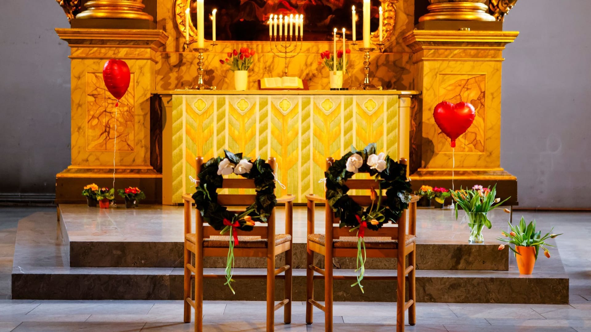 Geschmückte Stühle stehen vor dem Altar einer Kirche Geschmückte Stühle stehen vor dem Altar einer Kirche