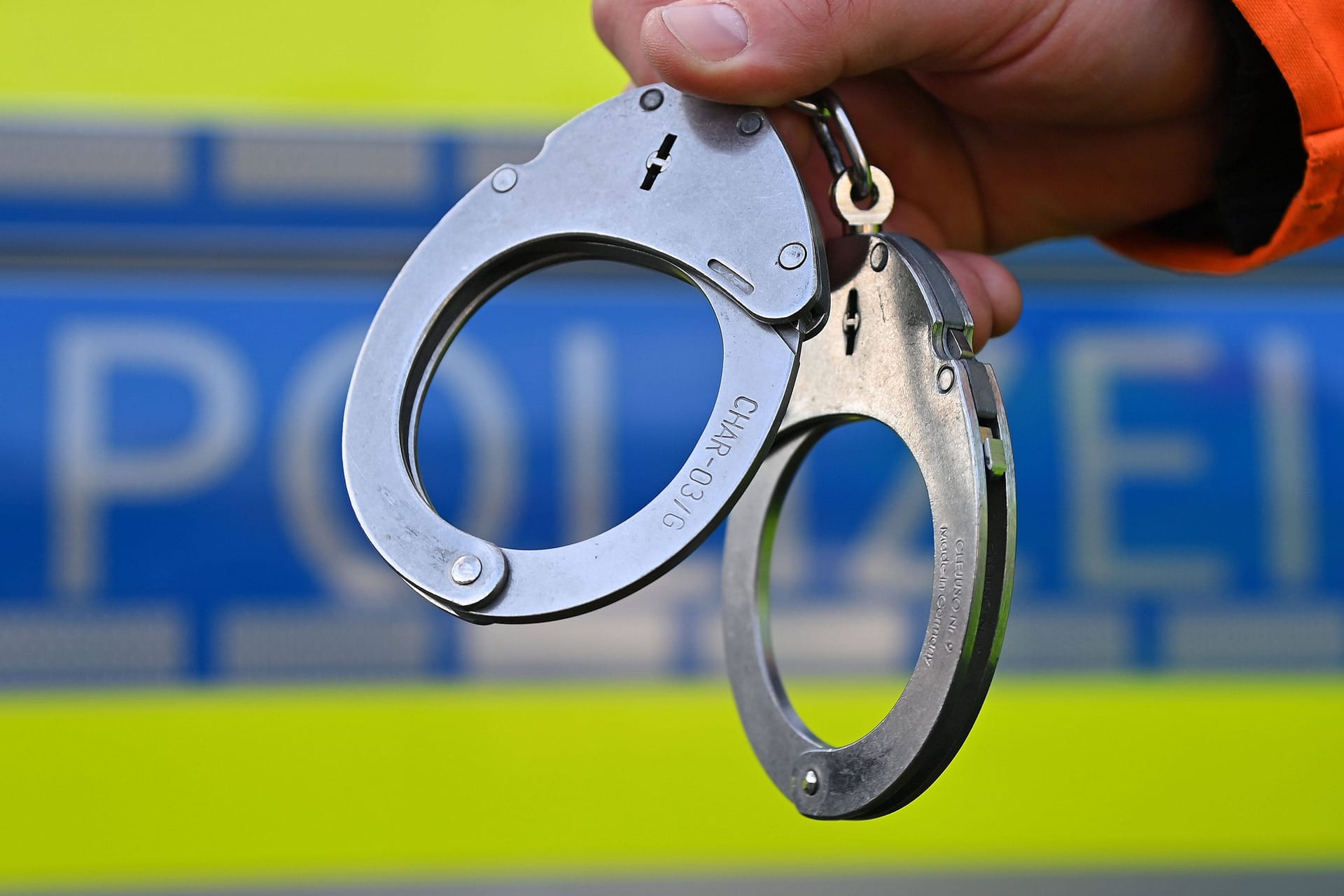 Eine Person hält Handschellen (Symbolbild): Die Polizei nahm drei betrunkene Randalierer in Salzgitter in Gewahrsam.