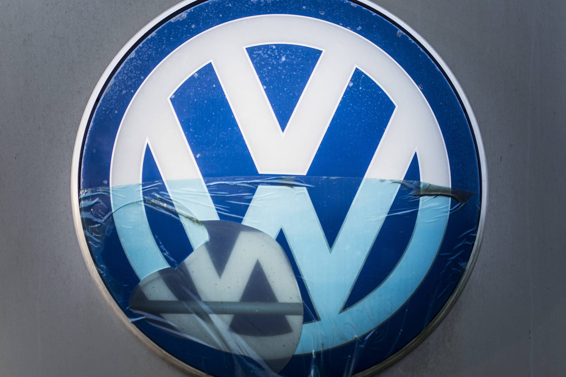 Ein beschädigtes VW-Logo (Symbolbild): Der Dieselskandal hat Volkswagen Milliarden gekostet – und bringt Manager nun in Erklärungsnot.