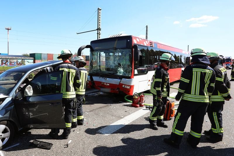 Einsatzkräfte der Feuerwehr stehen an der Unfallstelle auf der A59 bei Bonn. Ein Flughafenbus ist auf ein Stauende aufgefahren und hat fünf Autos ineinander geschoben - mehr als 20 Menschen sind dabei verletzt worden, wie die Polizei mitteilte.