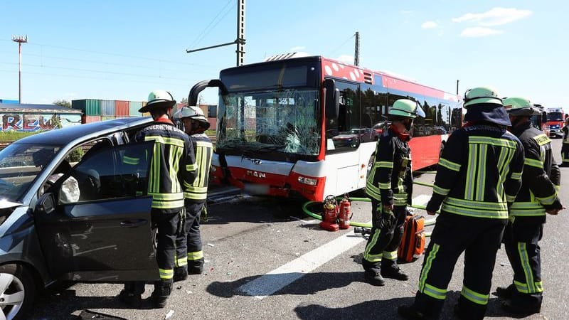Einsatzkräfte der Feuerwehr stehen an der Unfallstelle auf der A59 bei Bonn. Ein Flughafenbus ist auf ein Stauende aufgefahren und hat fünf Autos ineinander geschoben - mehr als 20 Menschen sind dabei verletzt worden, wie die Polizei mitteilte.