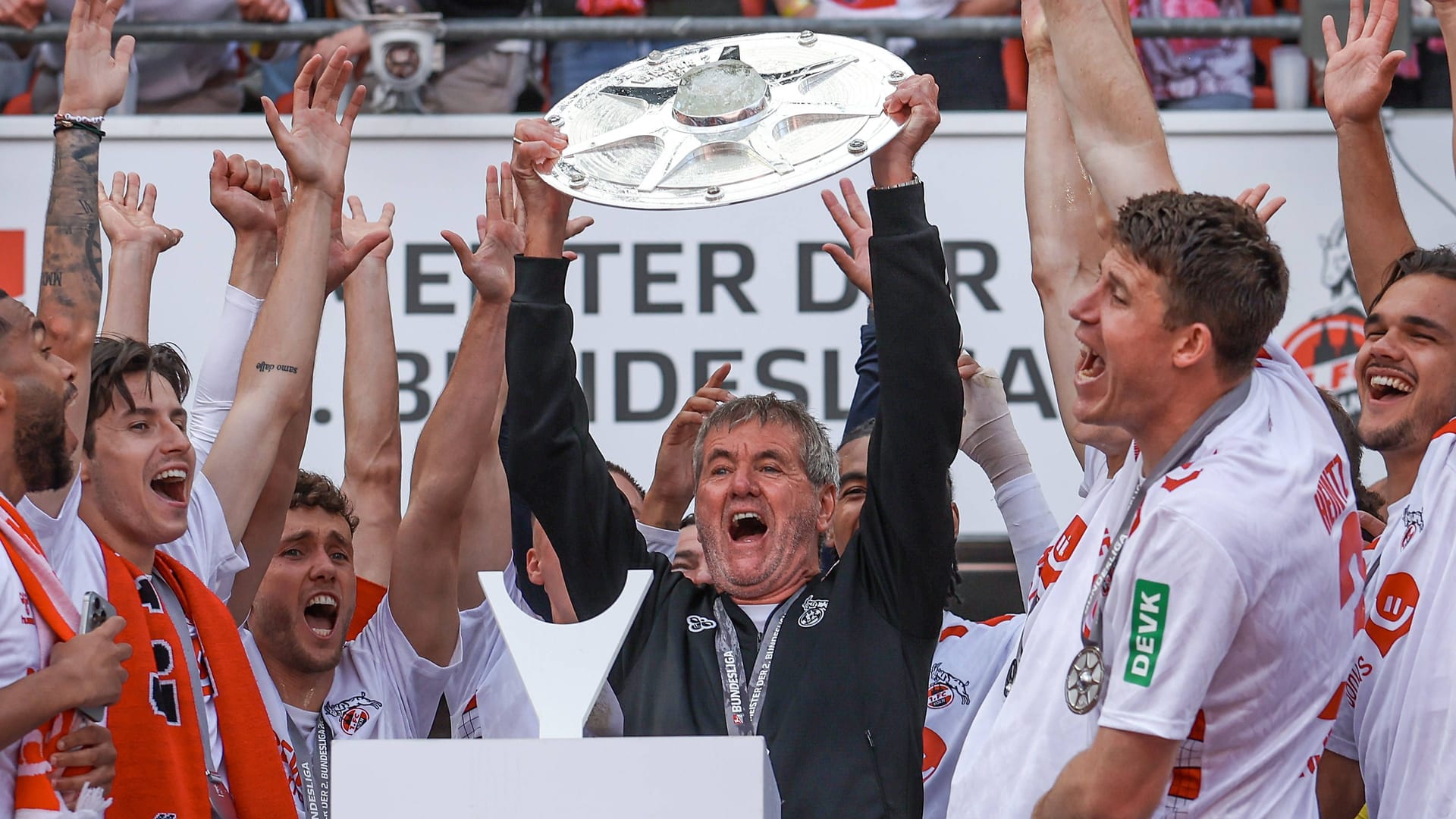 Triumph Bundesliga-Aufstieg: Köln-Trainer Friedhelm Funkel reckt die Meisterschale in die Höhe.