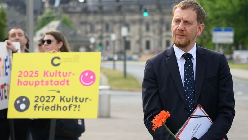 Michael Kretschmer (CDU), Ministerpräsident von Sachsen, steht vor Beginn der Sitzung des Sächsischen Landtages am Rande einer Protestkundgebung von sächsischen Theatern und Orchestern gegen die geplante Kürzung der Kulturausgaben vor dem Parlamentsgebäude.
