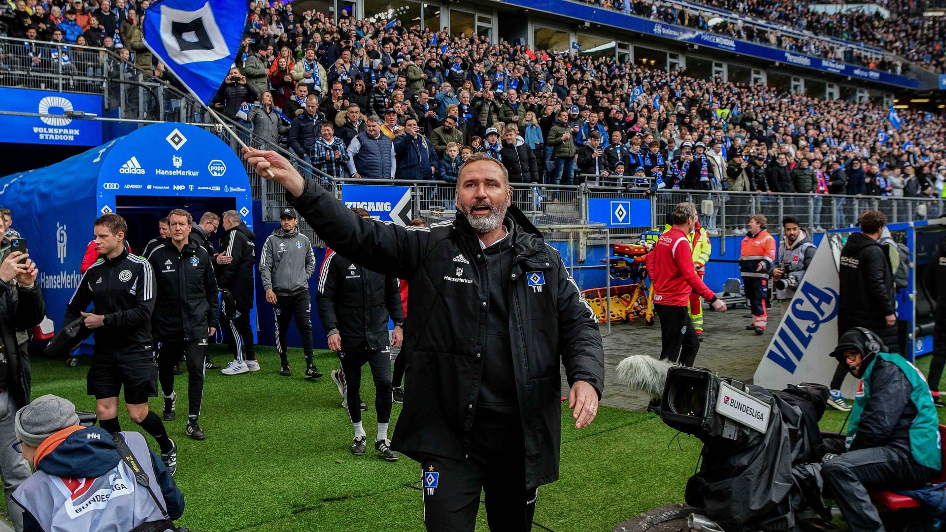 Tim Walter läuft mit HSV-Fahne im Volkspark ein (Archivbild): Der 49-Jährige ist einer von sieben Trainern, die mit dem Klub bislang am Aufstieg gescheitert sind.