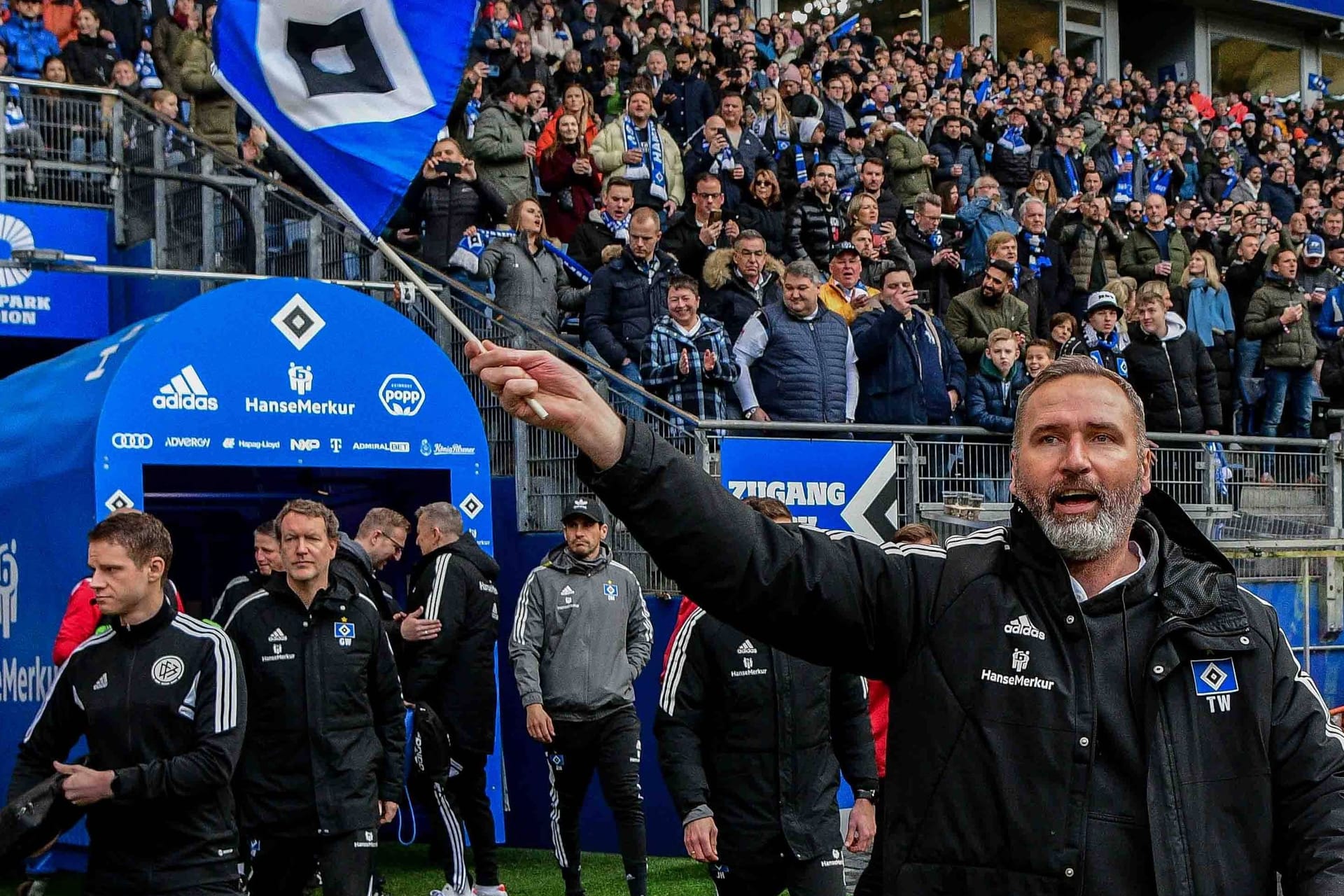 Tim Walter läuft mit HSV-Fahne im Volkspark ein (Archivbild): Der 49-Jährige ist einer von sieben Trainern, die mit dem Klub bislang am Aufstieg gescheitert sind.