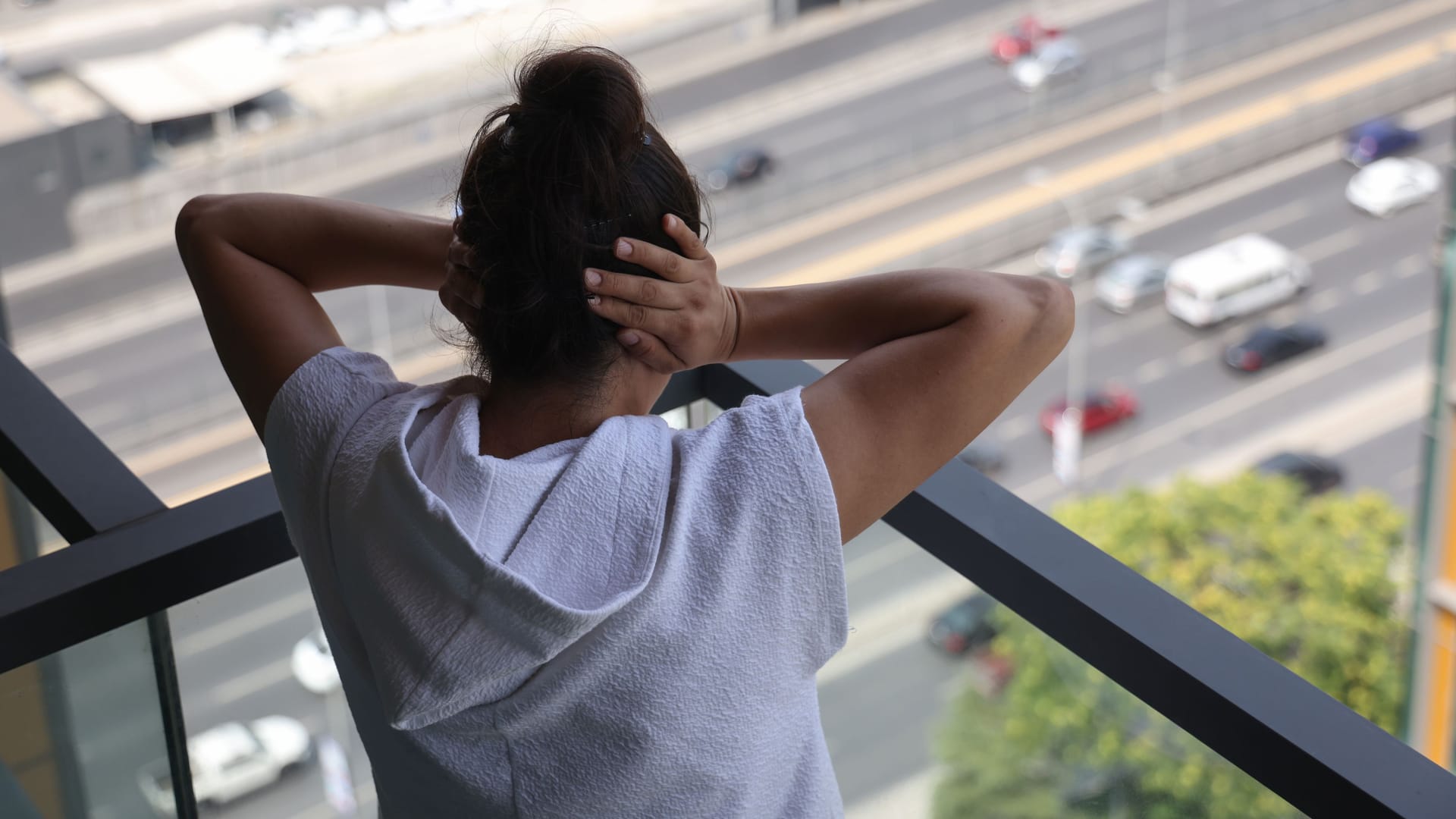 Eine Frau hält sich wegen Straßenlärm beide Ohren zu