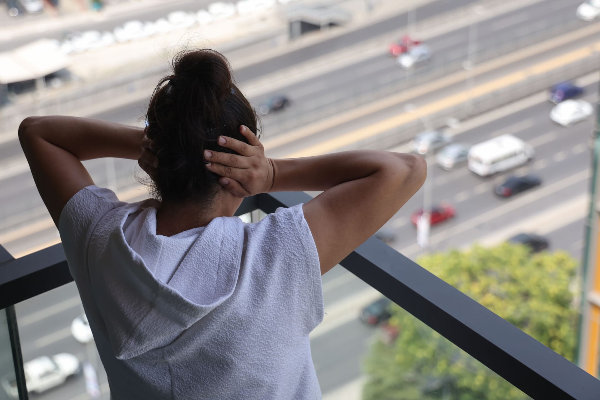 Eine Frau hält sich wegen Straßenlärm beide Ohren zu