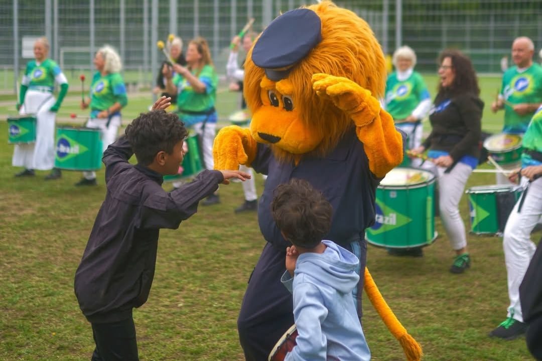 Das Polizeimaskottchen Lexi tanzt mit Kindern vor der Samba-Gruppe "Go-Brazil": Bei dem Fußballturnier gab es auch musikalische Vielfalt.