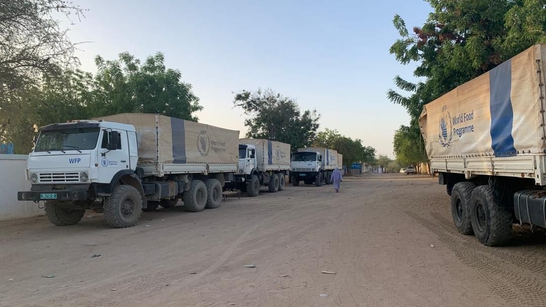 Lastwagen mit Hilfslieferungen für den Sudan stehen auf der tschadischen Seite der Grenze beider Länder: Die Hilfsgüter werden durch bürokratische Forderungen der Militärführung ausgebremst.