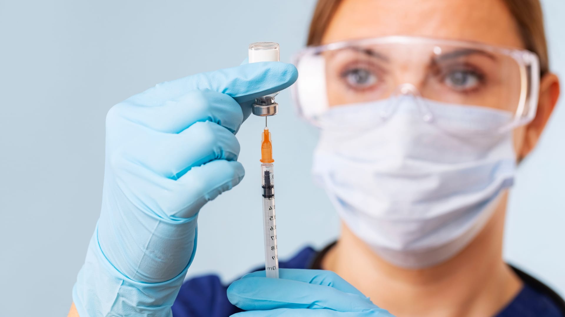 Doctor fills syringe with medicine from vial. Vaccination and immunization