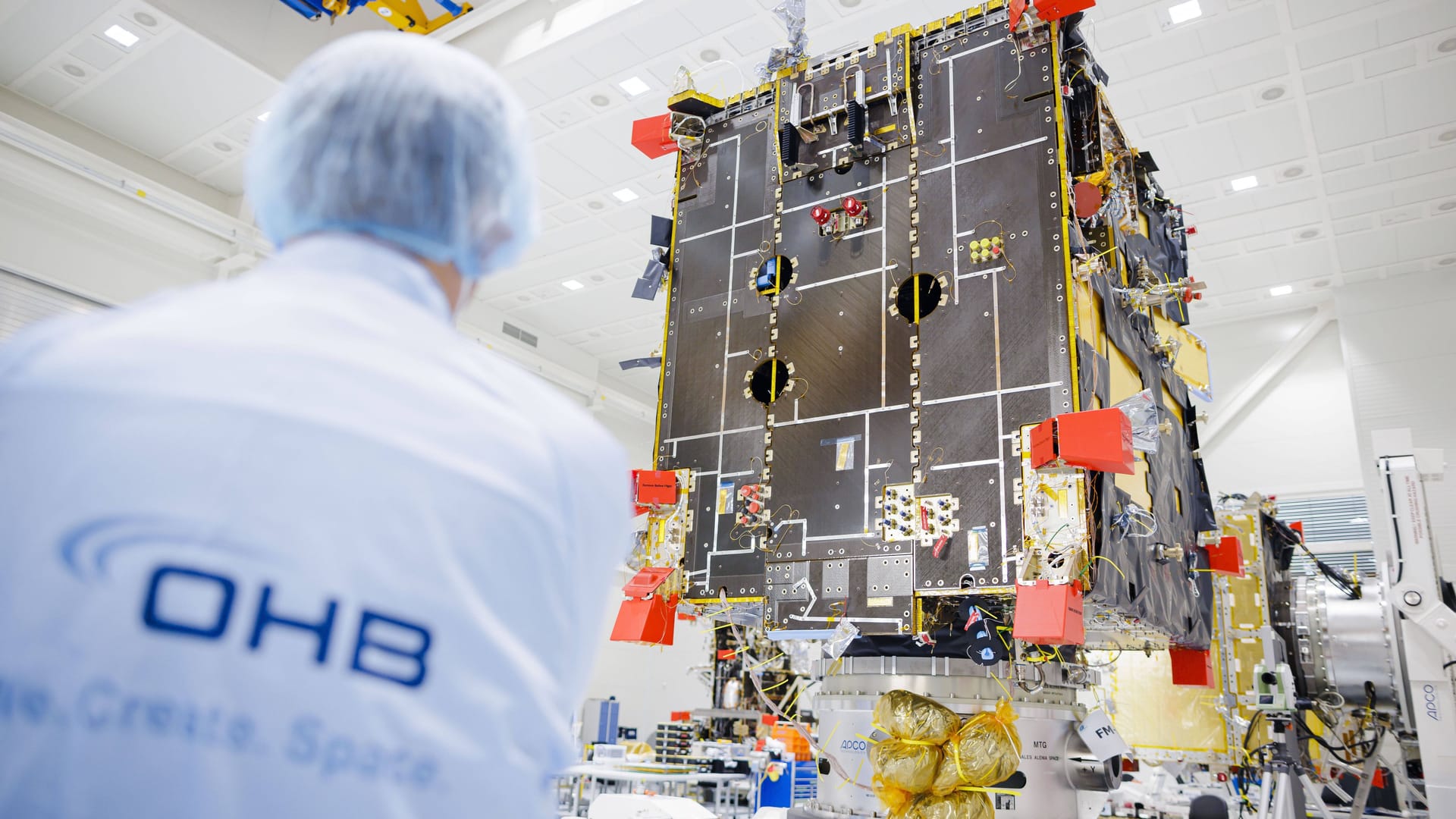 Mitarbeiter von OHB vor einem Wettersatelliten (Archivbild): Das Unternehmen zieht neben dem zivilen auch den militärischen Bereich als Wachstumsmarkt.