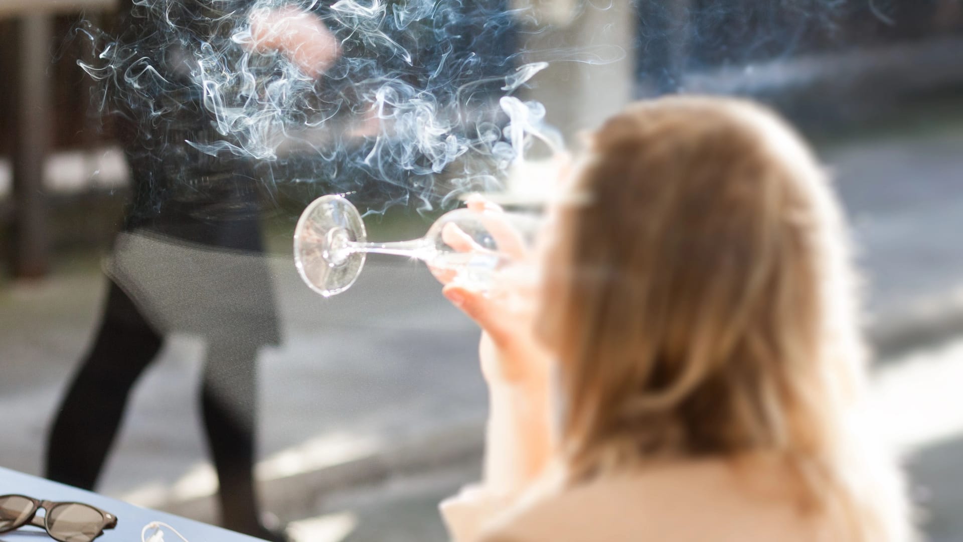 Eine Frau raucht auf der Terrasse einer Bar: Spanien verschärft die bestehenden Rauchverbote weiter (Symbolbild).