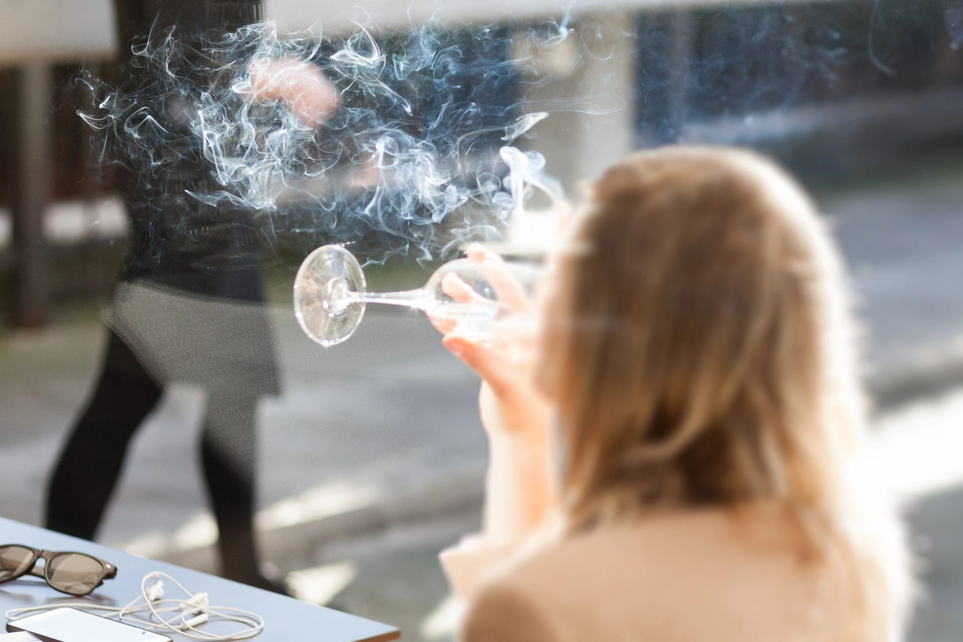 Eine Frau raucht auf der Terrasse einer Bar: Spanien verschärft die bestehenden Rauchverbote weiter (Symbolbild).