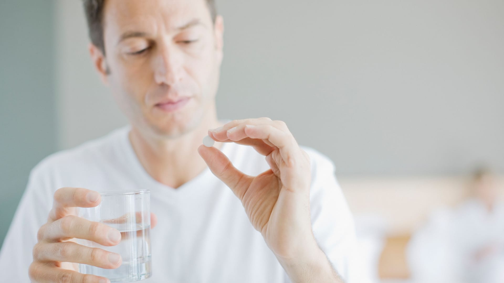 Ein Mann mit Wasserglas und Tablette Ein Mann mit Wasserglas und Tablette