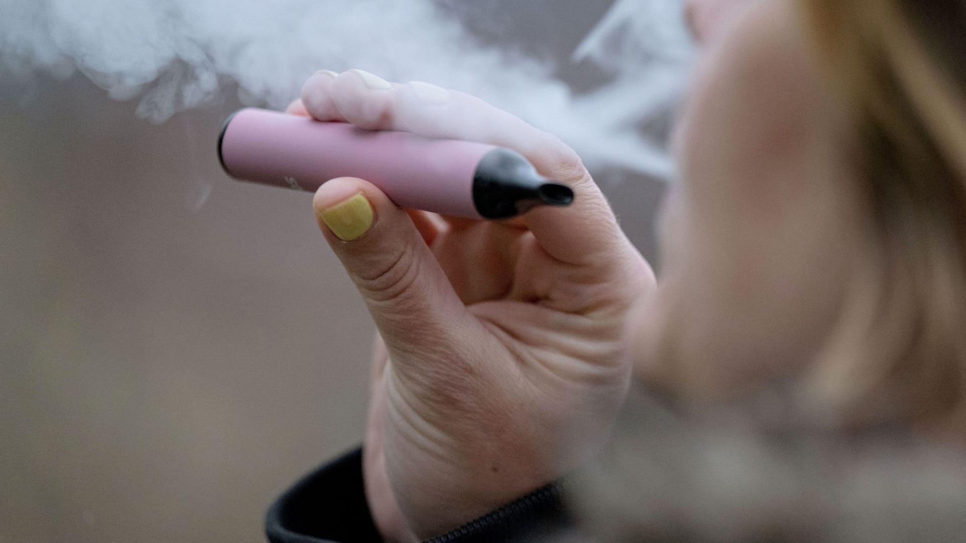Eine Frau konsumiert eine E-Zigarette: Niedersachsen weitet Rauchverbot auf Vapes und Cannabis aus.