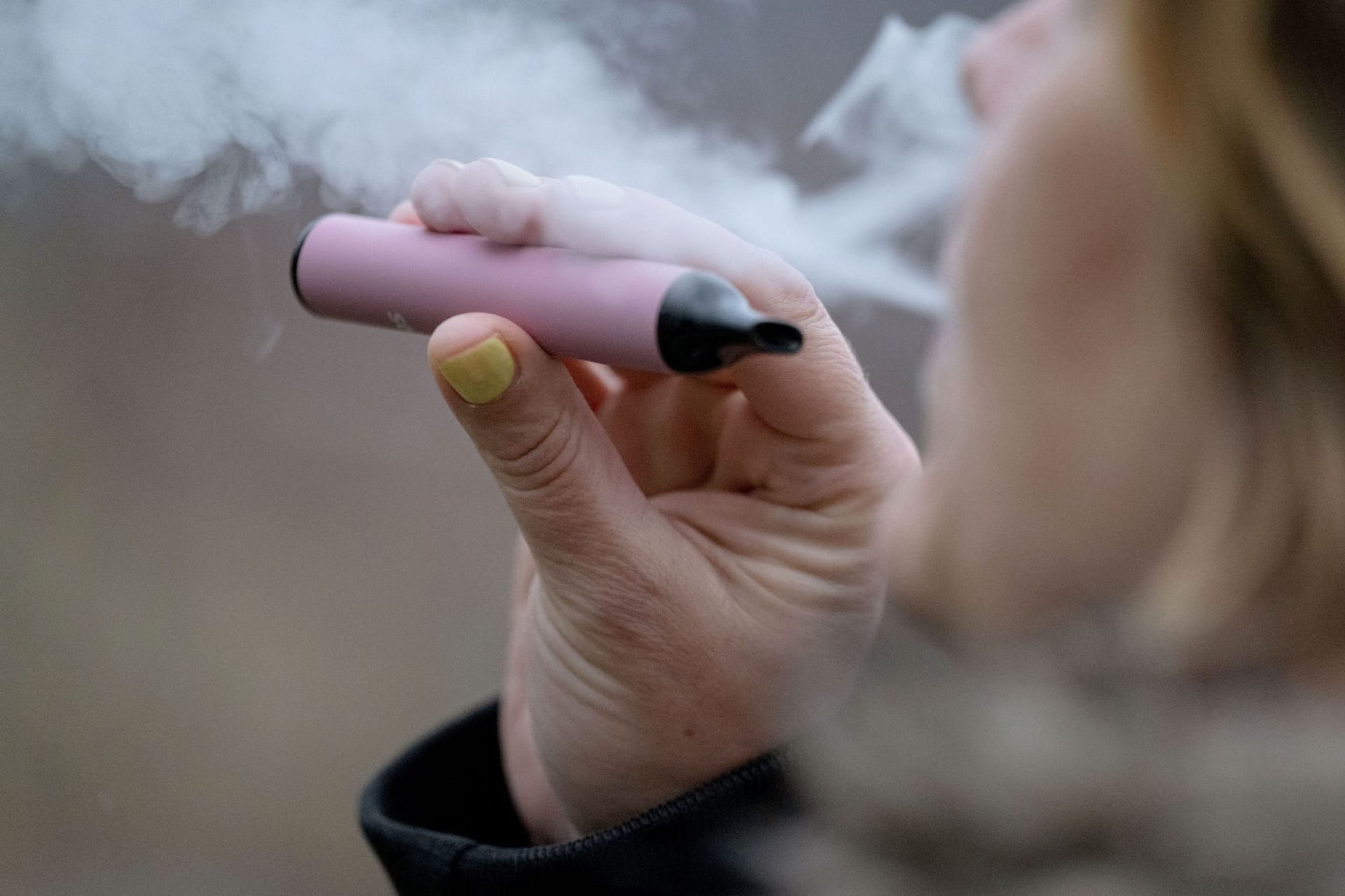 Eine Frau konsumiert eine E-Zigarette: Niedersachsen weitet Rauchverbot auf Vapes und Cannabis aus.