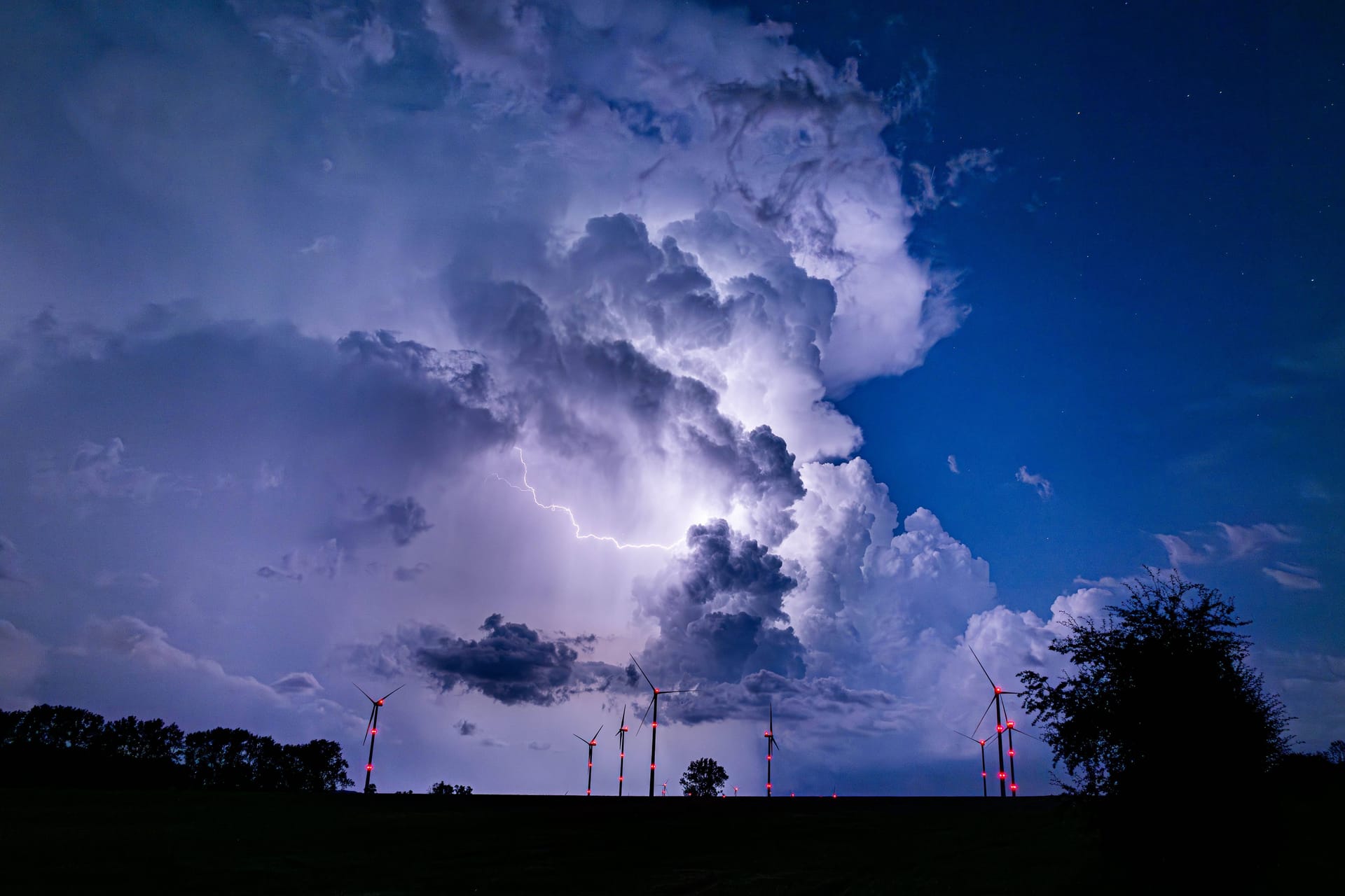 Eine Gewitterzelle verdunkelt den Himmel während eines Unwetters (Archivbild): In Köln und der Region werden am Wochenende schwere Unwetter und Starkregen erwartet.