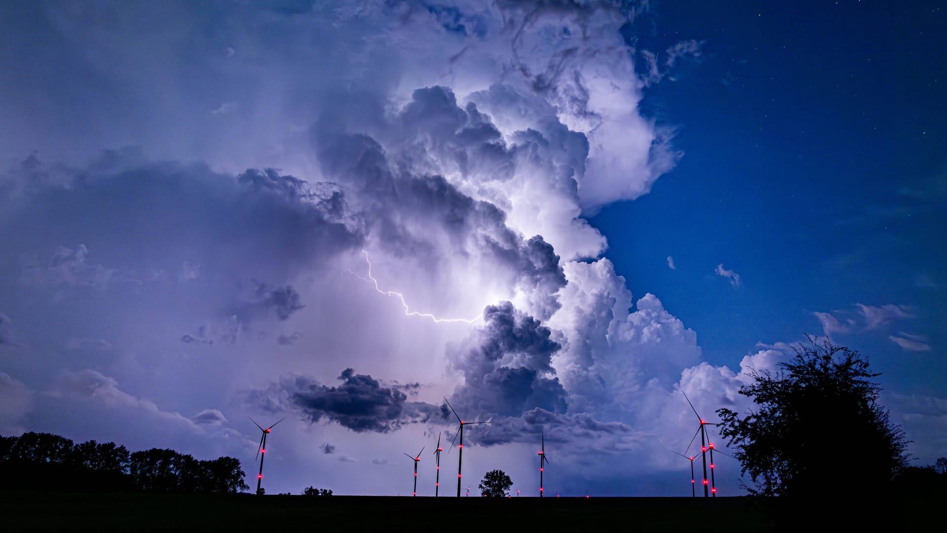Eine Gewitterzelle verdunkelt den Himmel während eines Unwetters (Archivbild): In Köln und der Region werden am Wochenende schwere Unwetter und Starkregen erwartet.